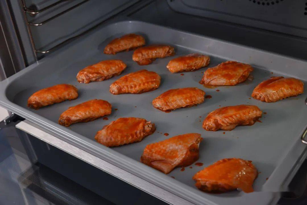 烤25分钟,而后将蜂蜜和清水调匀涂在鸡翅表面,最后再进烤箱烤5分钟