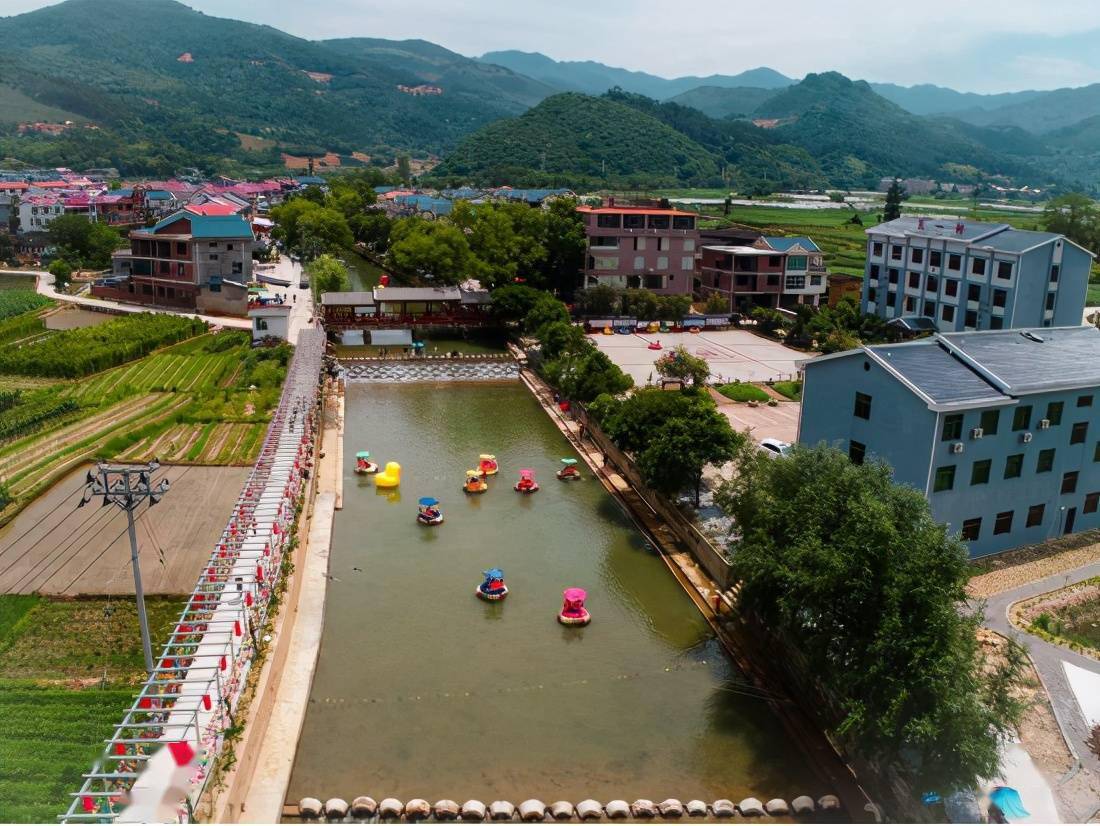 5月5日,在永安市小陶镇五一村,不少游客在清澈的河面上,一边体验脚踏