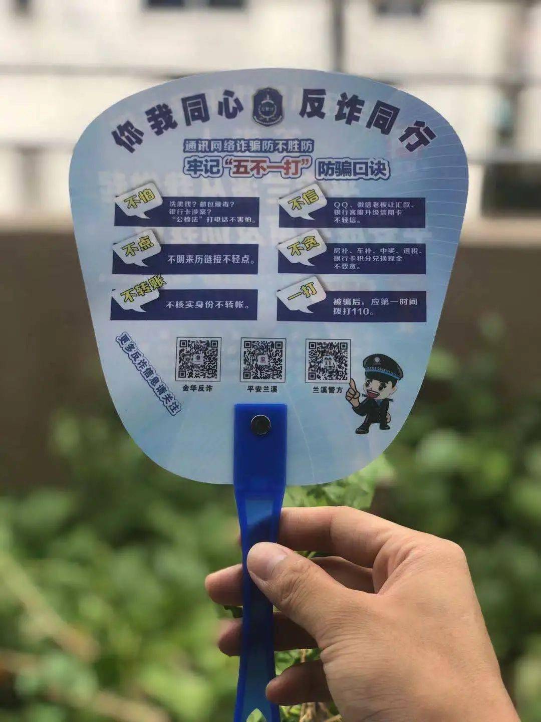 在景点周边摆摊设点,为来赏花看景的市民送上一把"反诈扇子"