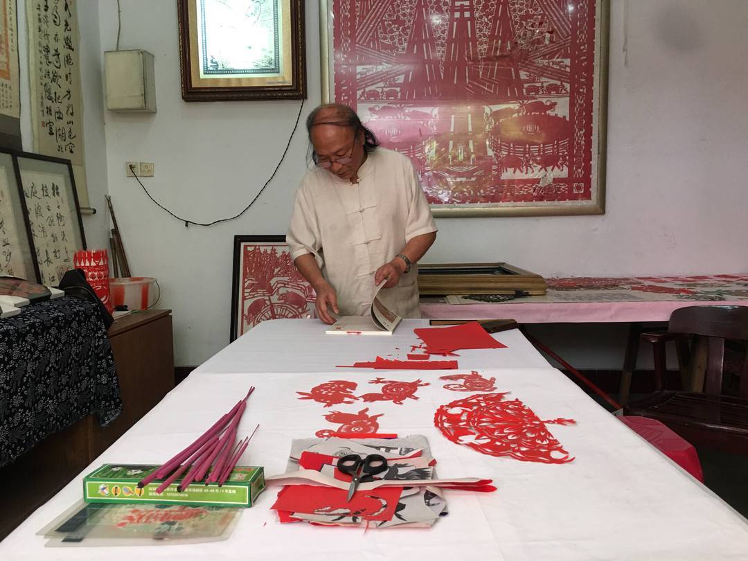 7月25日,在自贡市自流井区釜溪步行街,省级非遗自贡剪纸代表性传承人