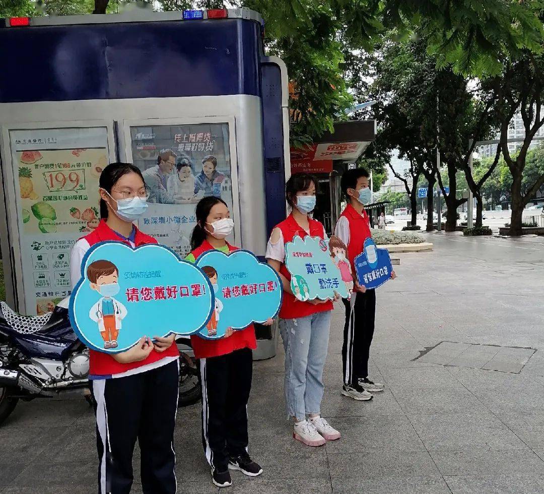 科学馆u站的志愿者走上街头一手宣传牌,一手"大声公"反复提醒市民戴好