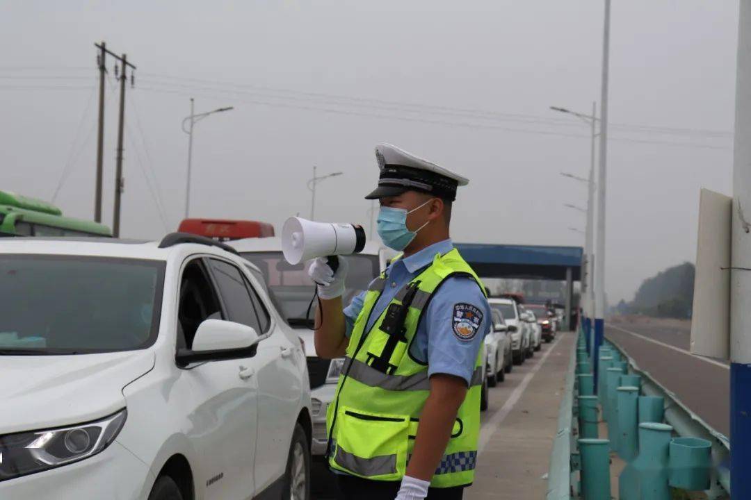 在疫情防控聯合執勤點,交警們指揮車輛,配合衛生防疫,交通運輸