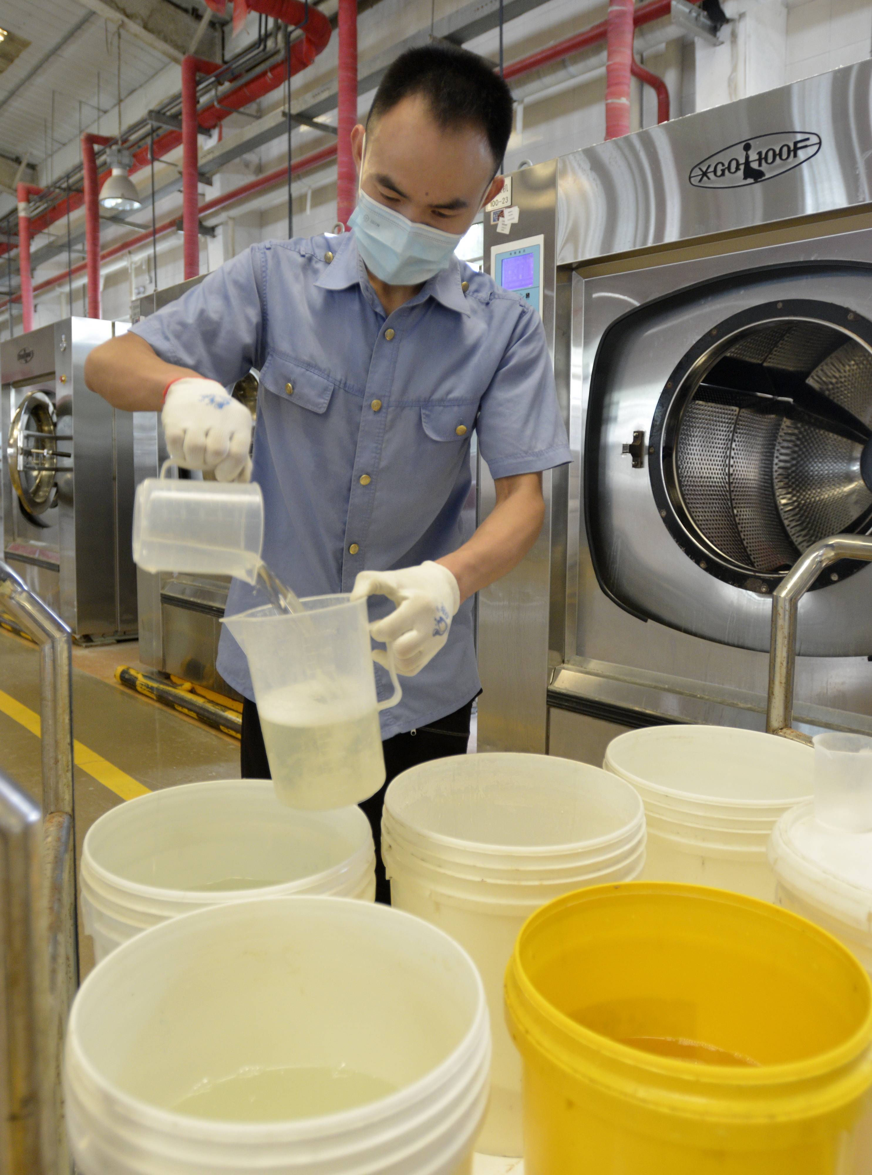 8月23日,北京客运段洗涤车间的工作人员在进行二次消毒洗涤前的准备