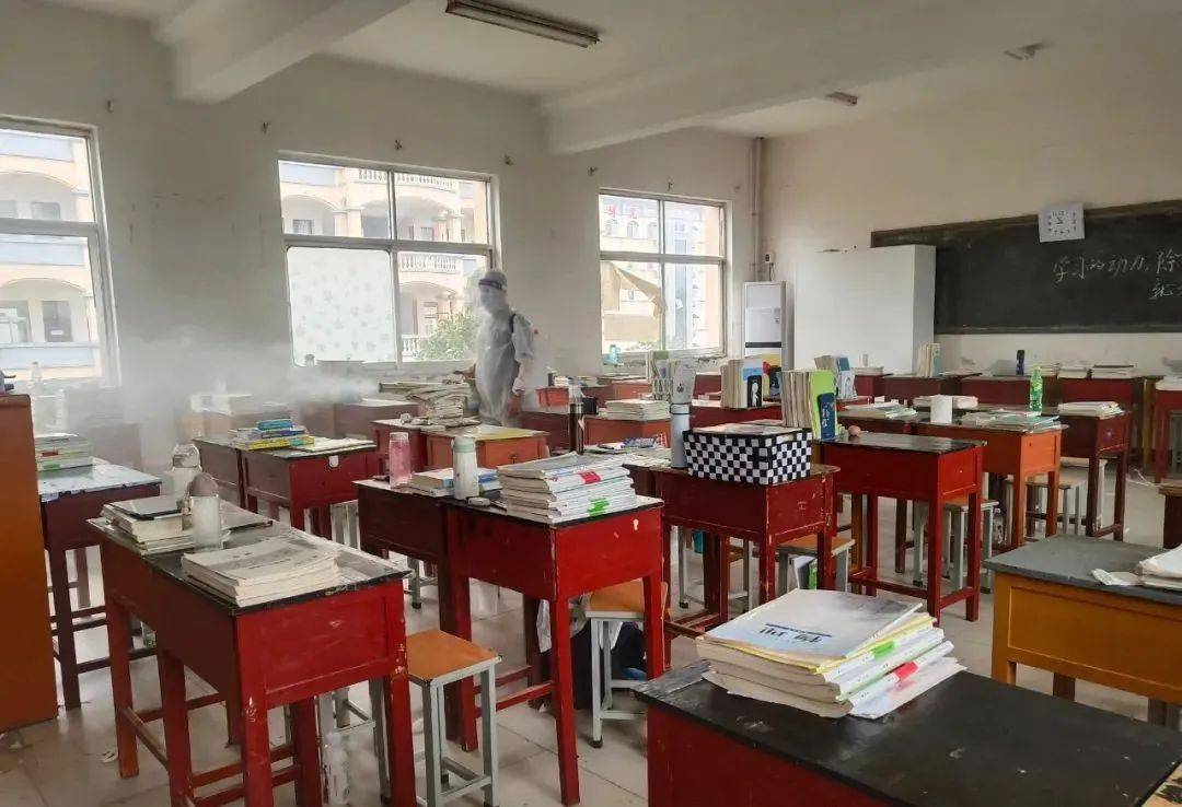 肩背几十斤重的弥雾机,在夏邑县第一高级中学,工作人员身穿防护服