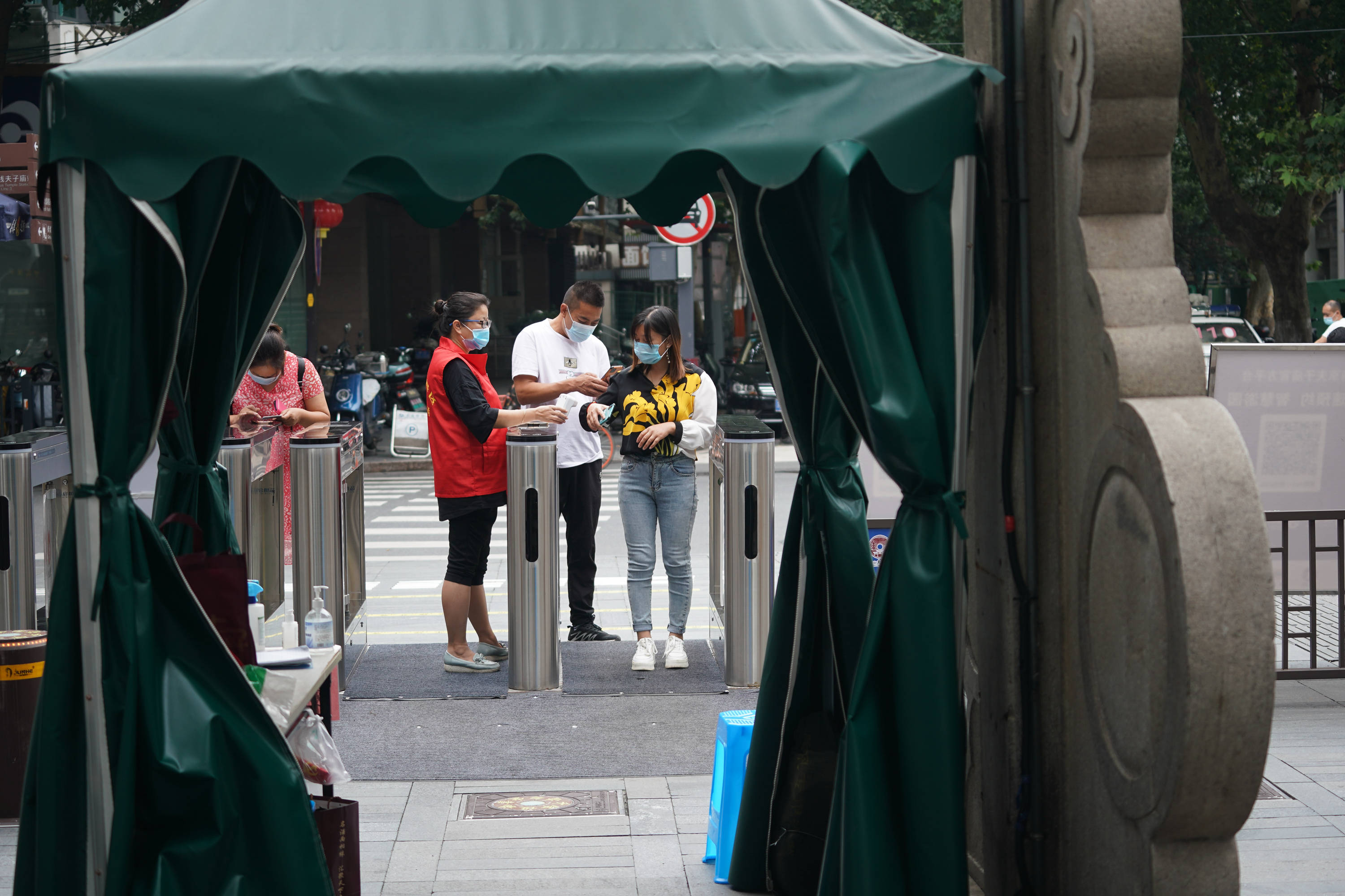 8月27日,南京夫子庙景区工作人员在入口处为游客测温查码.