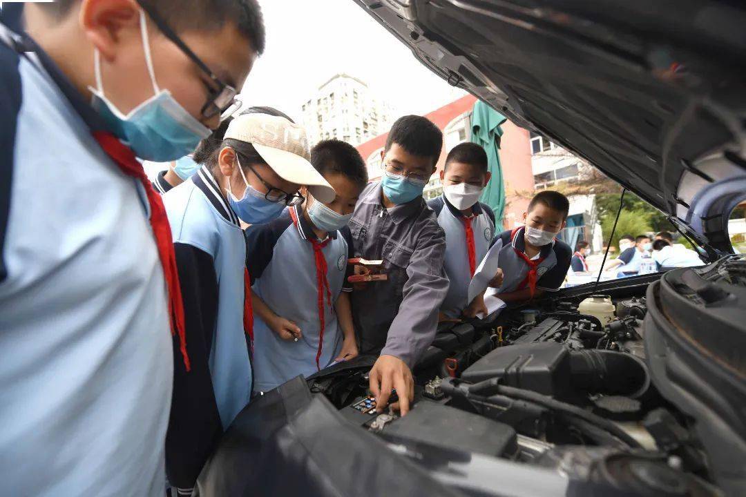 同樣是在趙登禹學校,豐職智能汽車技術運用專業教師劉強正帶著學生圍