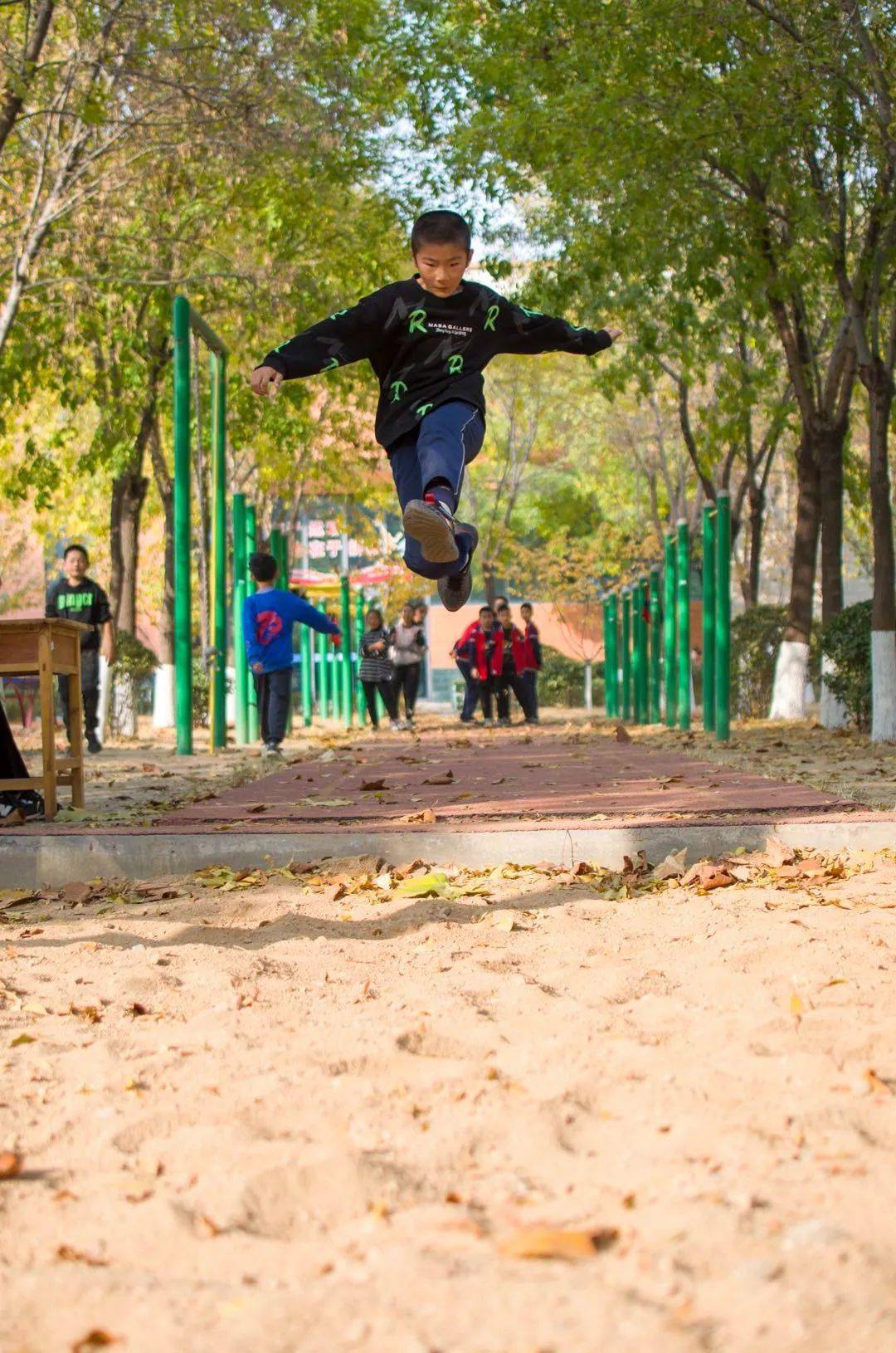 明珠小学操场上到处都是跳跃的同学教学楼在阳光下闪闪发光清洁工人