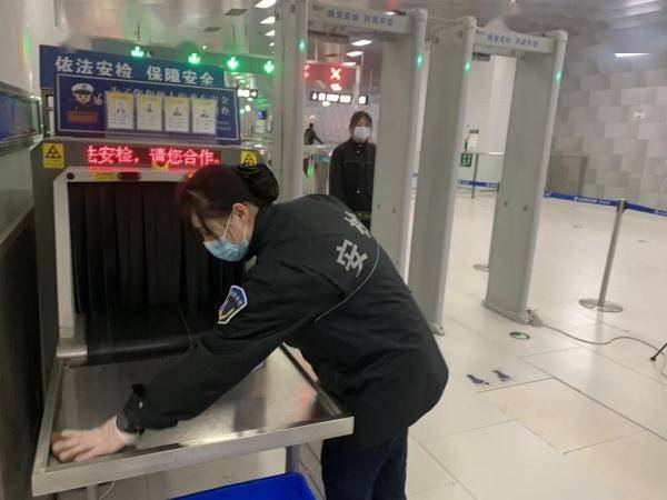地铁安检人员定时对安检机消毒擦拭/北京交通广播记者拍摄地铁呼家楼
