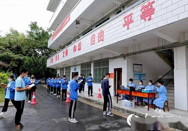 瑞丽市第一民族中学内,高三学生排队等待核算采样登记时争分夺秒看书