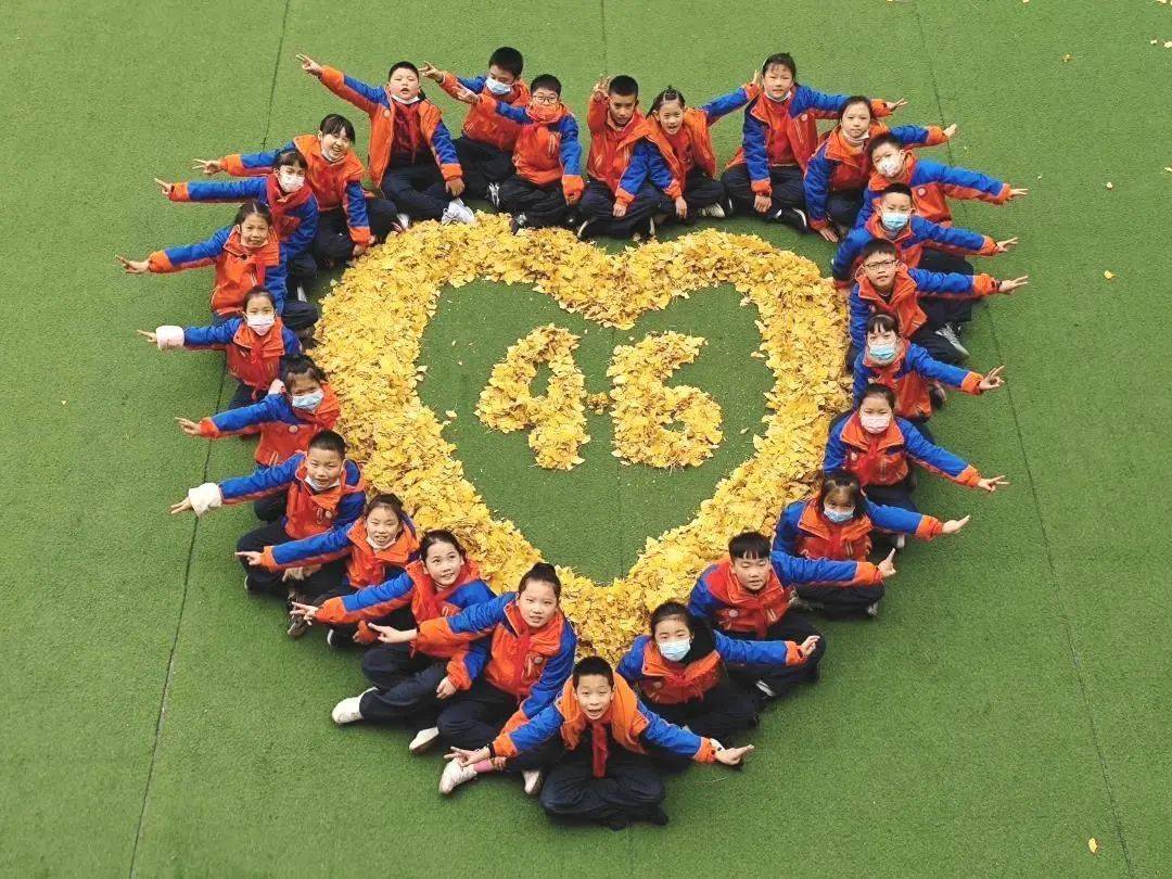 是孩子们想要留住美景的小小心思落在地上的树叶被摆成爱心的形状笑着