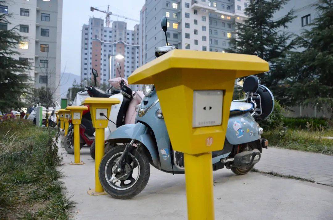在电动车集中停放点看到一排排电动车整齐地停在智慧充电桩前,李育琪