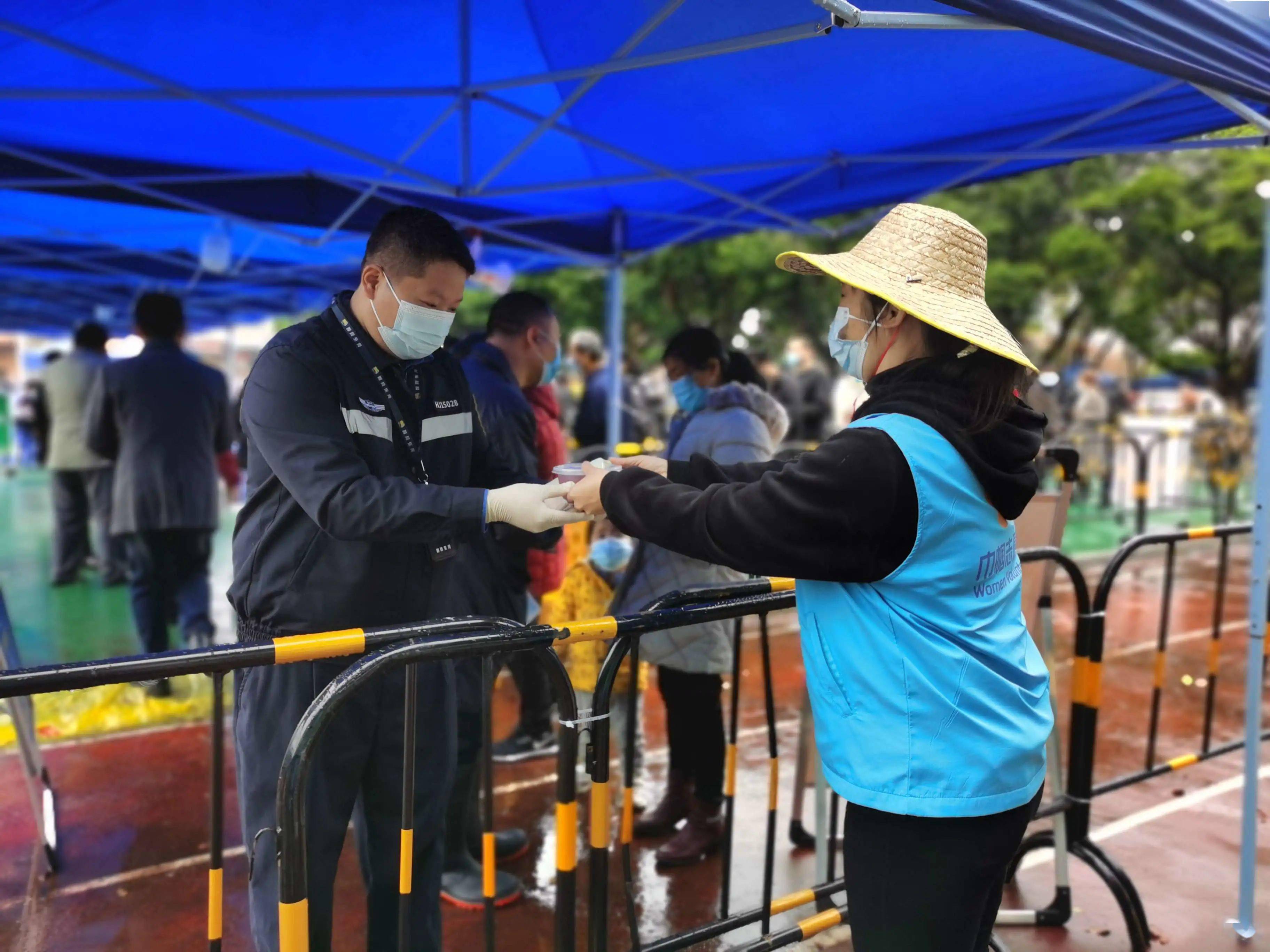 厚街社区鳌台公园核酸采样点,空中不断传来防疫广播提示,市民披上雨衣