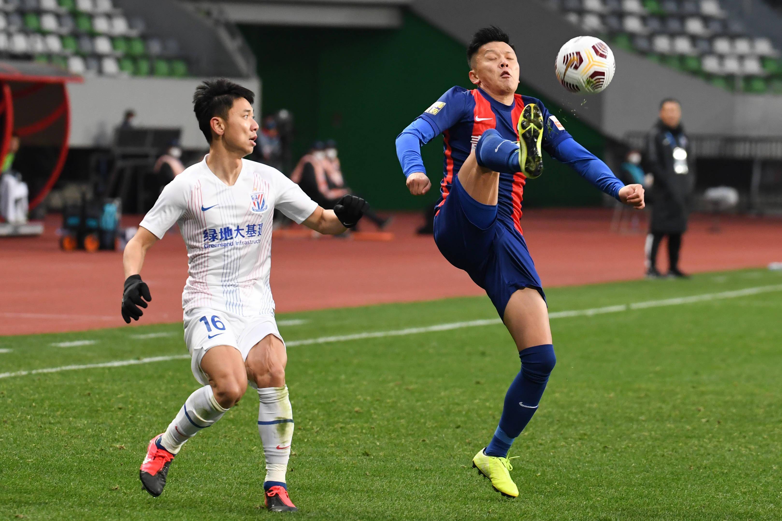 苏州(江苏),2021年12月25日12月25日,青岛队球员邹正(右)与上海申花队