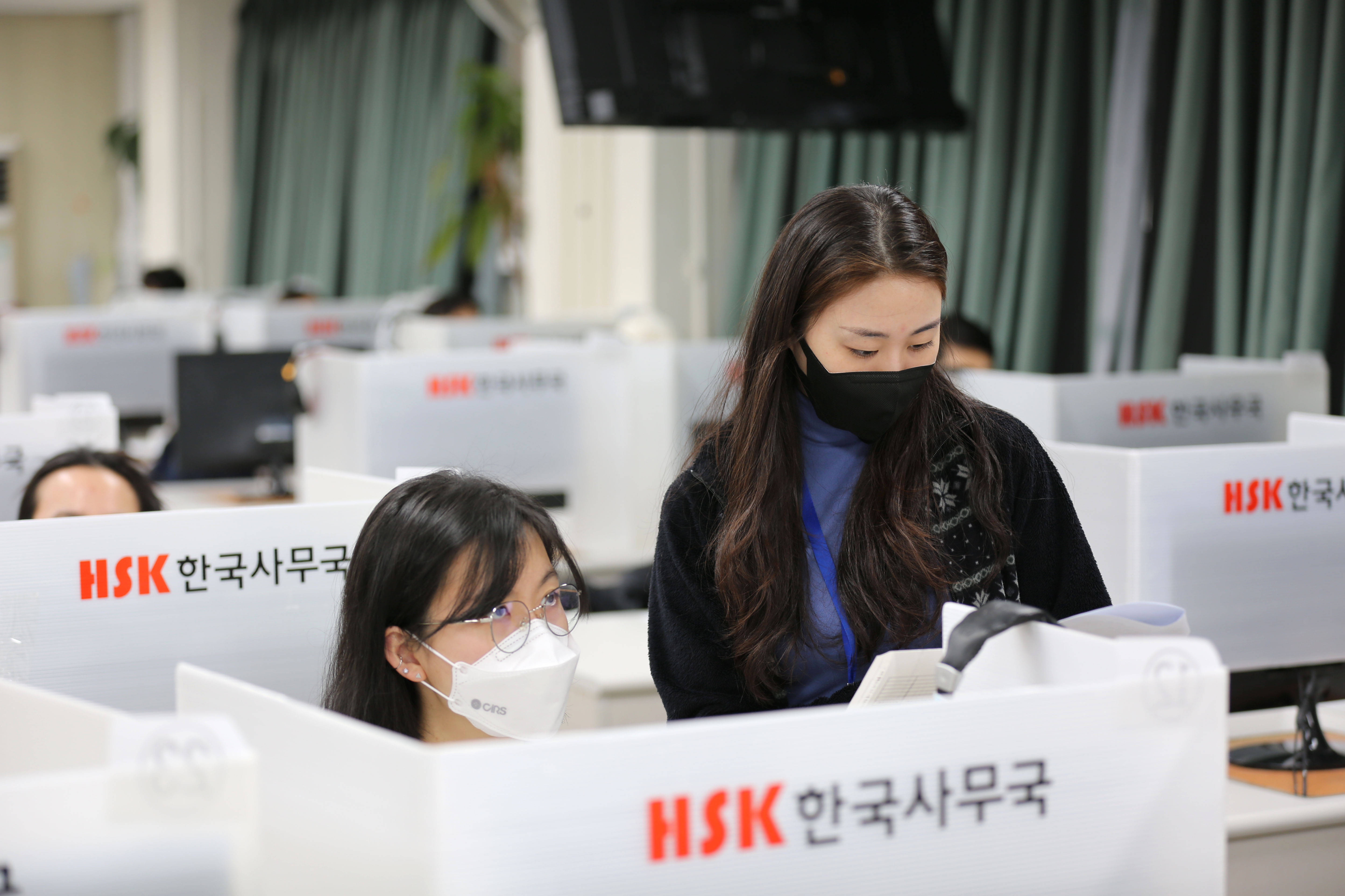 2月19日,在韩国首尔的韩国汉城华侨中学,监考老师核查考生信息.