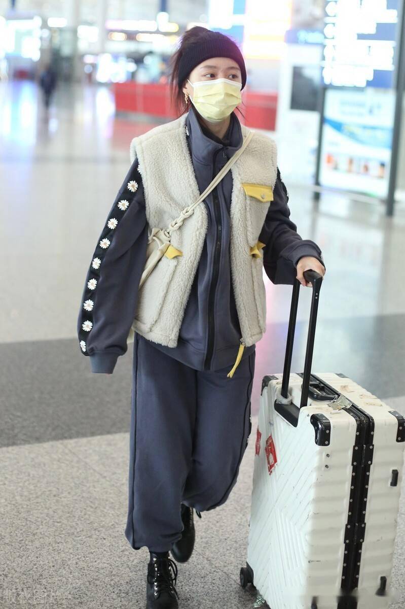 黄婷婷身穿白色毛绒马甲搭卫衣套装,头发高扎状态好_机场_北京_黄婷婷