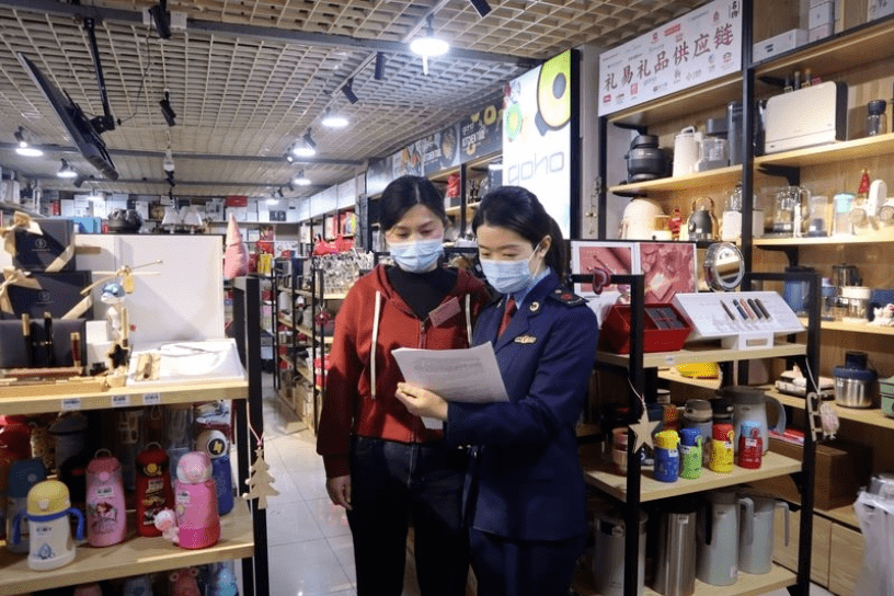 "在金华聚流食品商行,婺城区市场监管局干部方琳娜和金华成泰农商银行