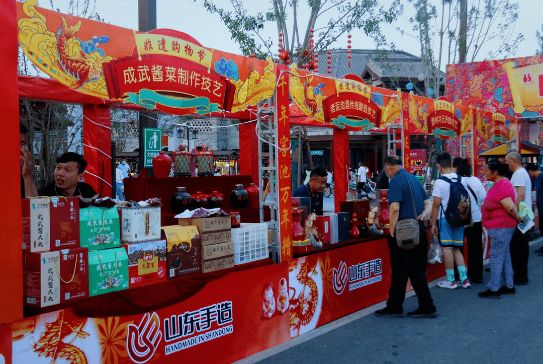 两侧摊位井然有序,设计布置充满民俗特色,各式非遗工艺琳琅满目,令人