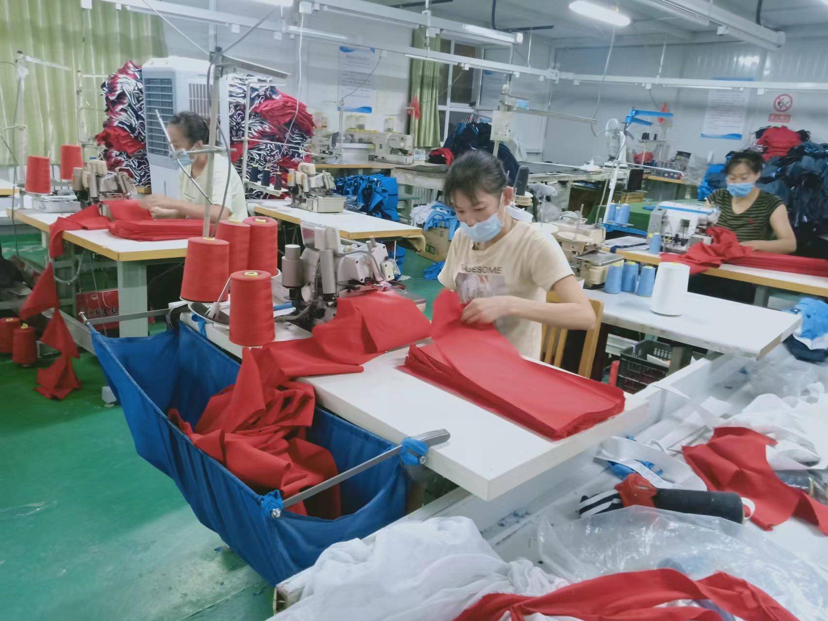 多台缝纫机嗒嗒作响,多名工人鼓足干劲,加班加点紧急生产防疫保