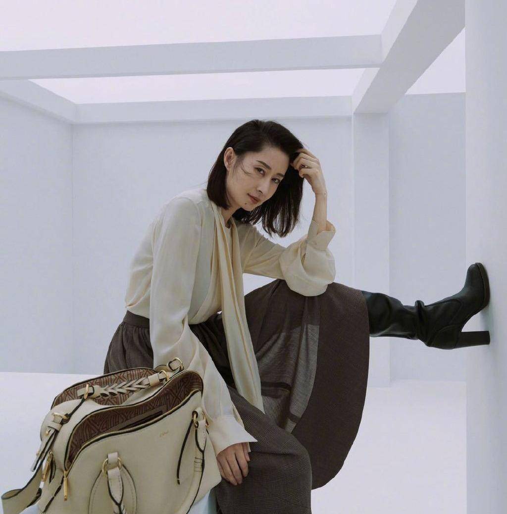 44岁刘敏涛更高调了,穿衬衫长裙配黑色长筒靴,脚踢墙上好霸气_衣服