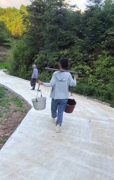 (王翠利和奶奶去挑水,王翠利把路翻修后,奶奶出行更便利与安全了.