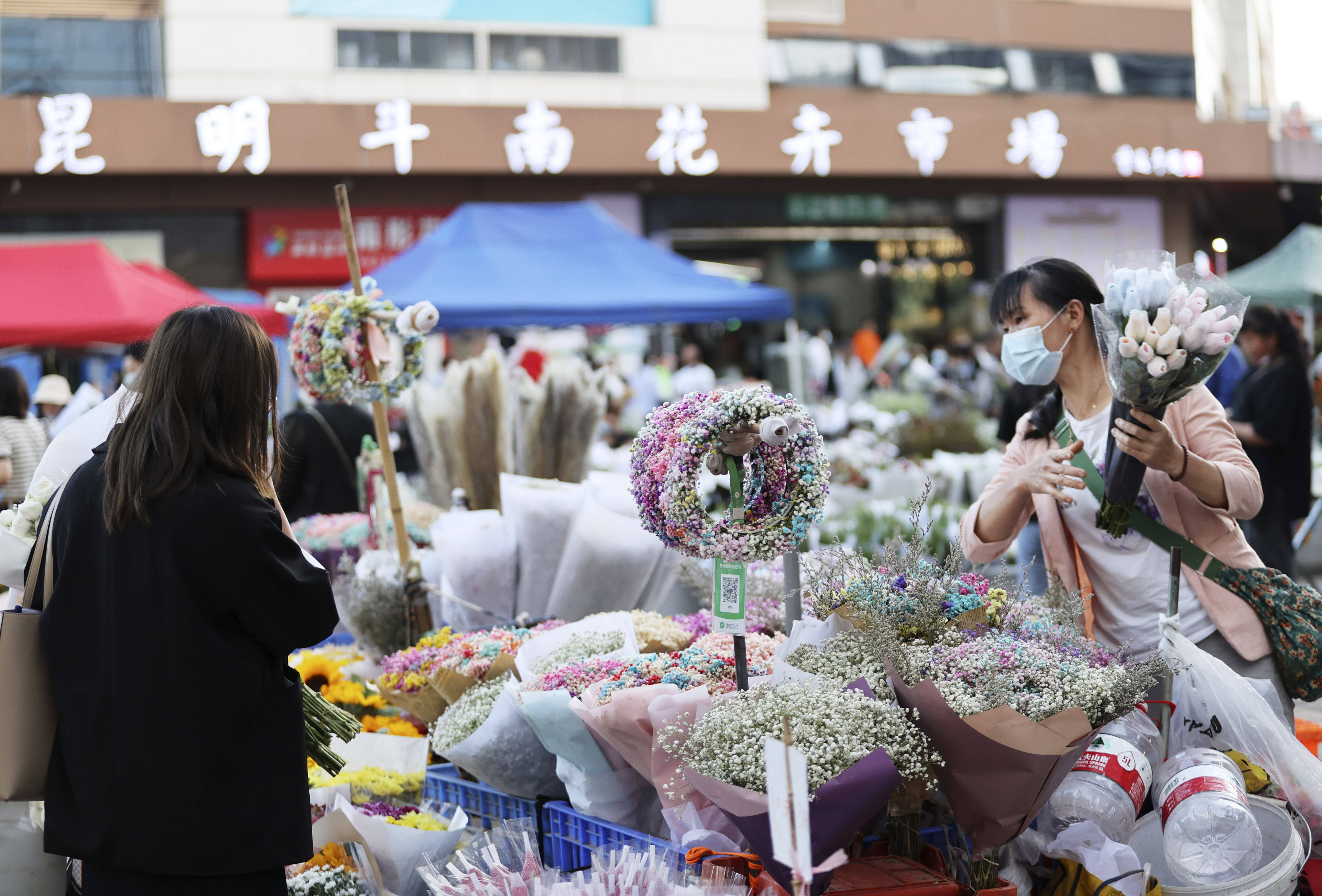 游客在昆明斗南花卉交易市场选购鲜花