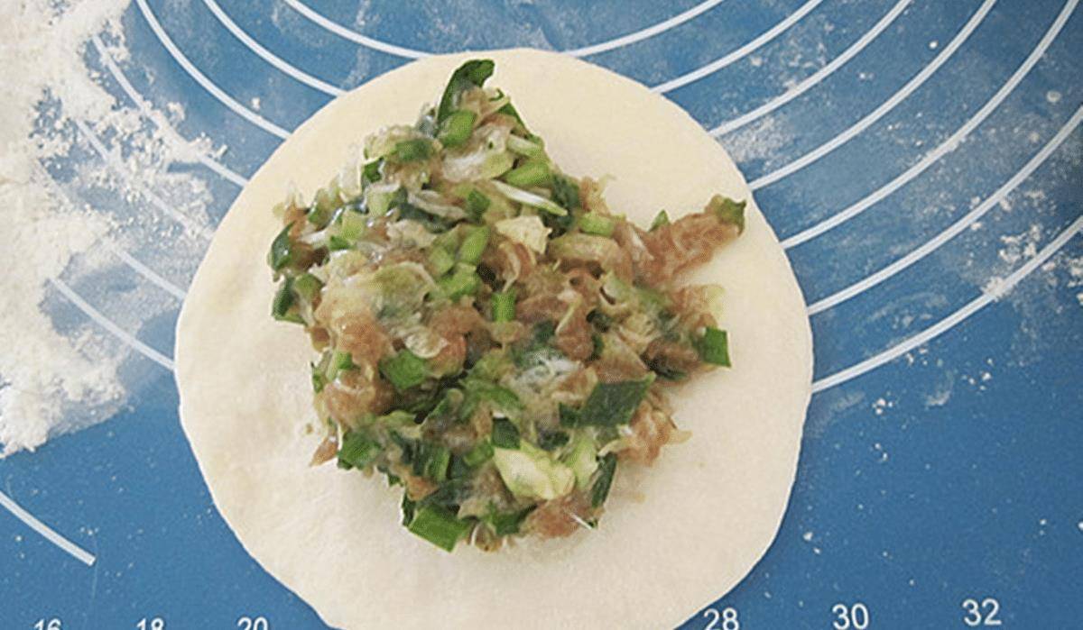 剁碎后的槐花放入搅打上劲的肉馅中拌匀,再加入之前切好的韭菜段再次