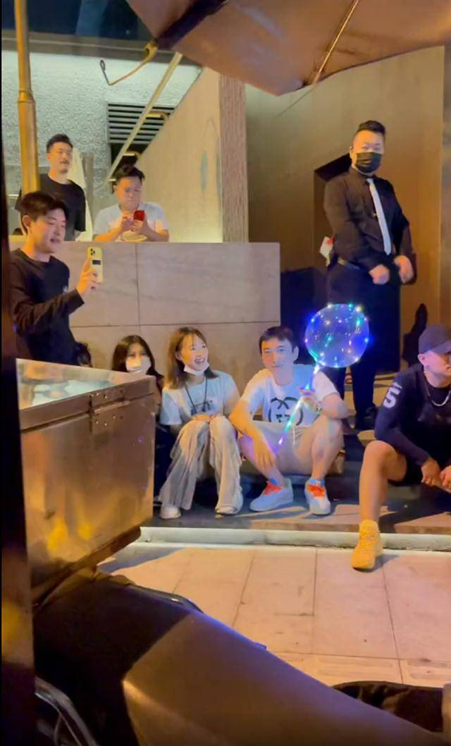 当天,王思聪深夜现身酒吧,他"接地气"地蹲在一旁,手拿着发光气球不断