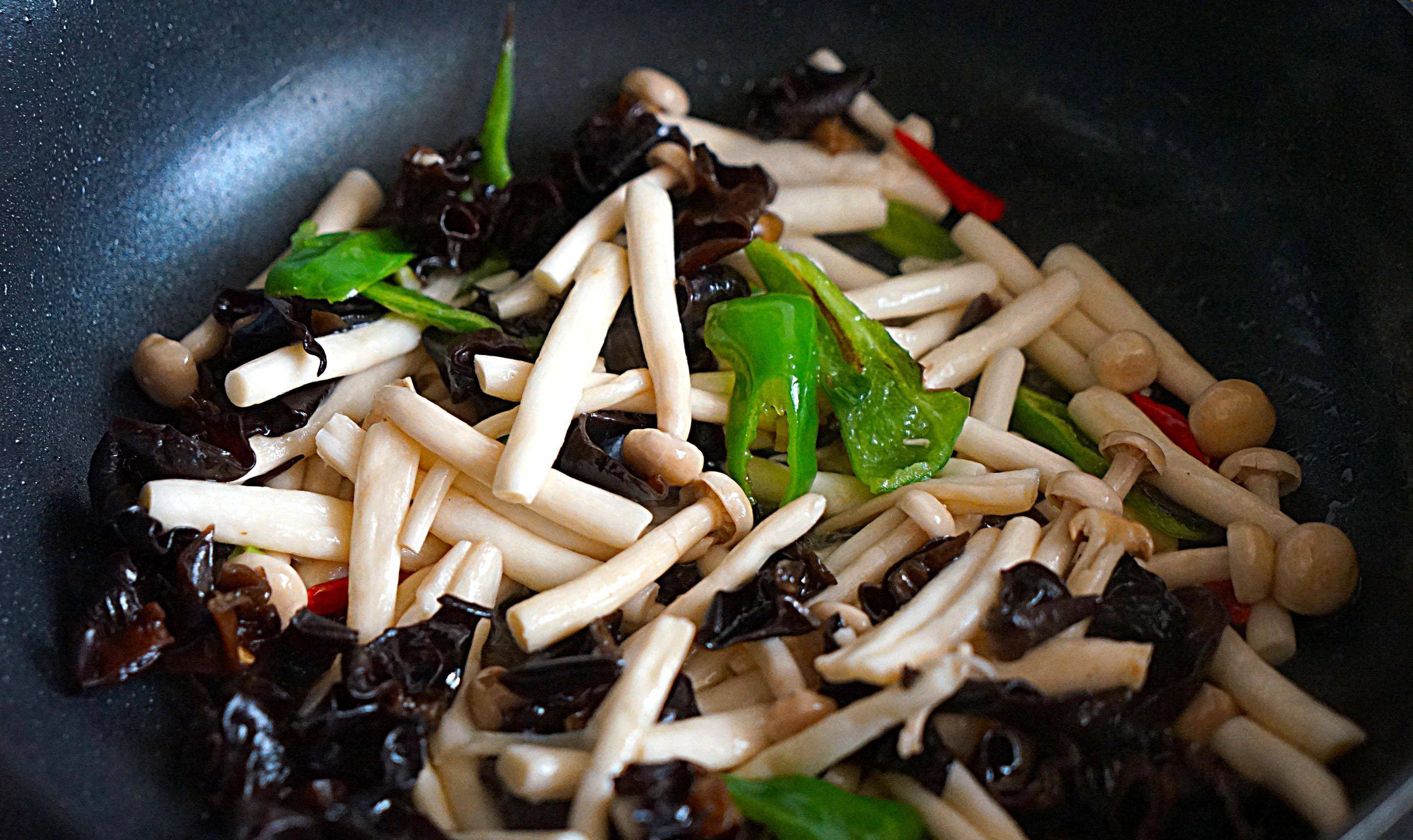 7,倒入黑木耳和白玉菇,大火翻炒均匀.