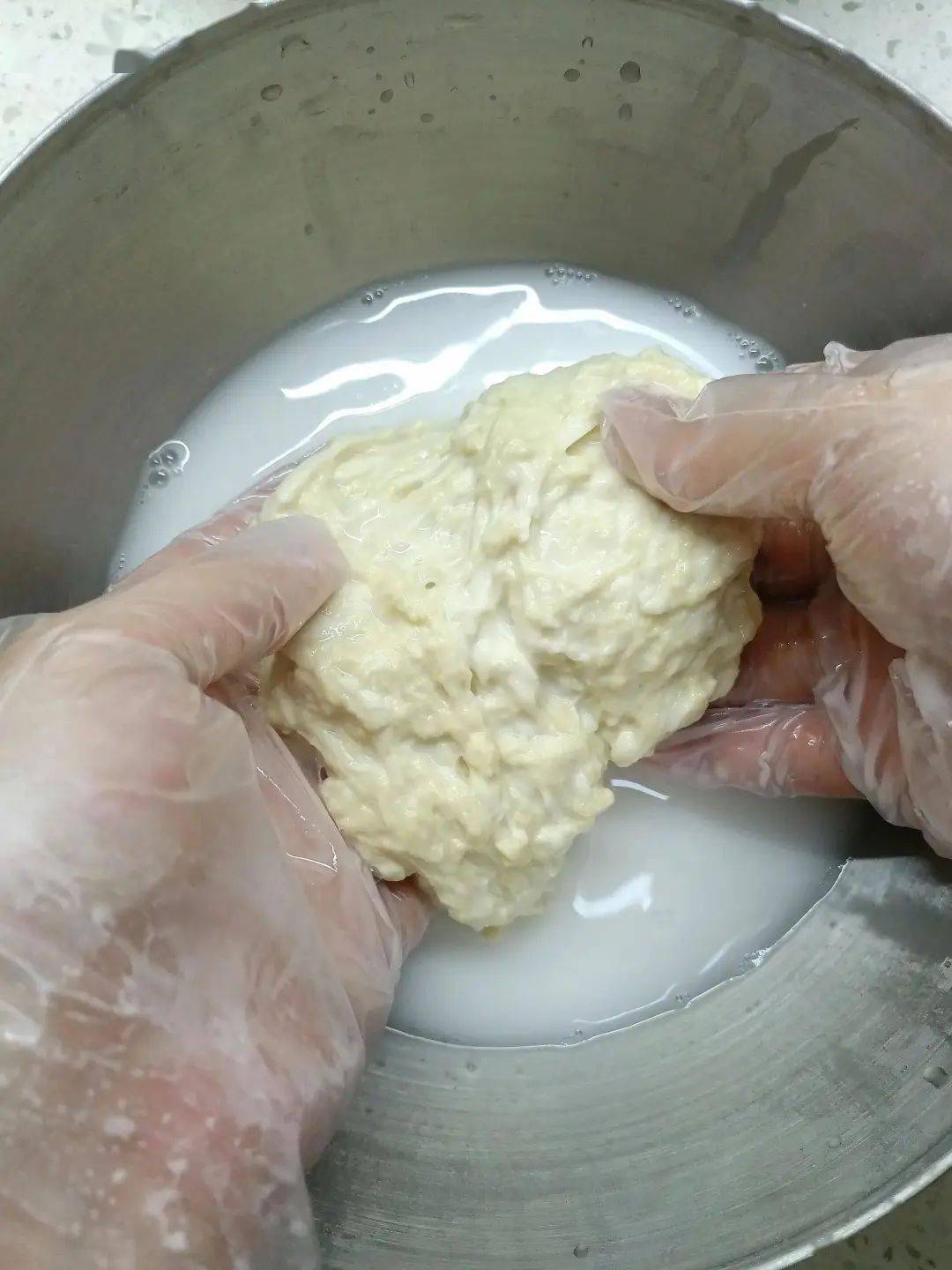 7.加入清水继续洗面筋,这时面筋已经逐步成形6.