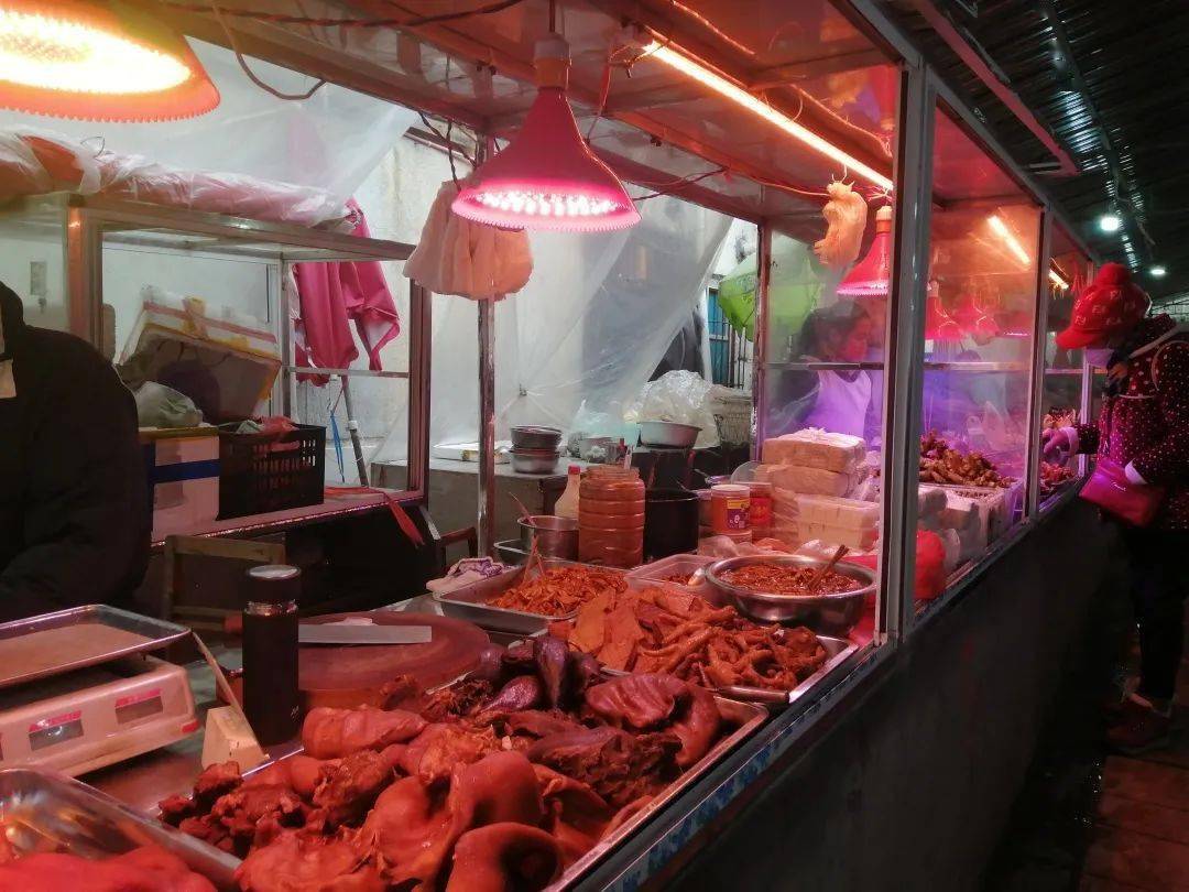 菜市场卤肉摊前,各式卤肉色泽诱人,整齐地摆放在摊位上.