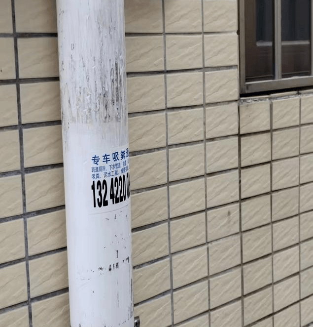 达公司对村庄辖区内建筑物外墙和电线杆上的牛皮癣进行日常清理工作