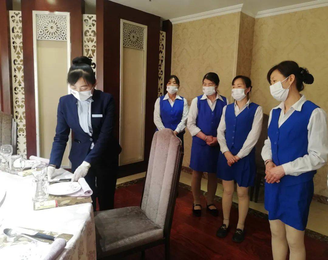 领班丁丽娟正在为服务员示范讲解摆台的服务技能