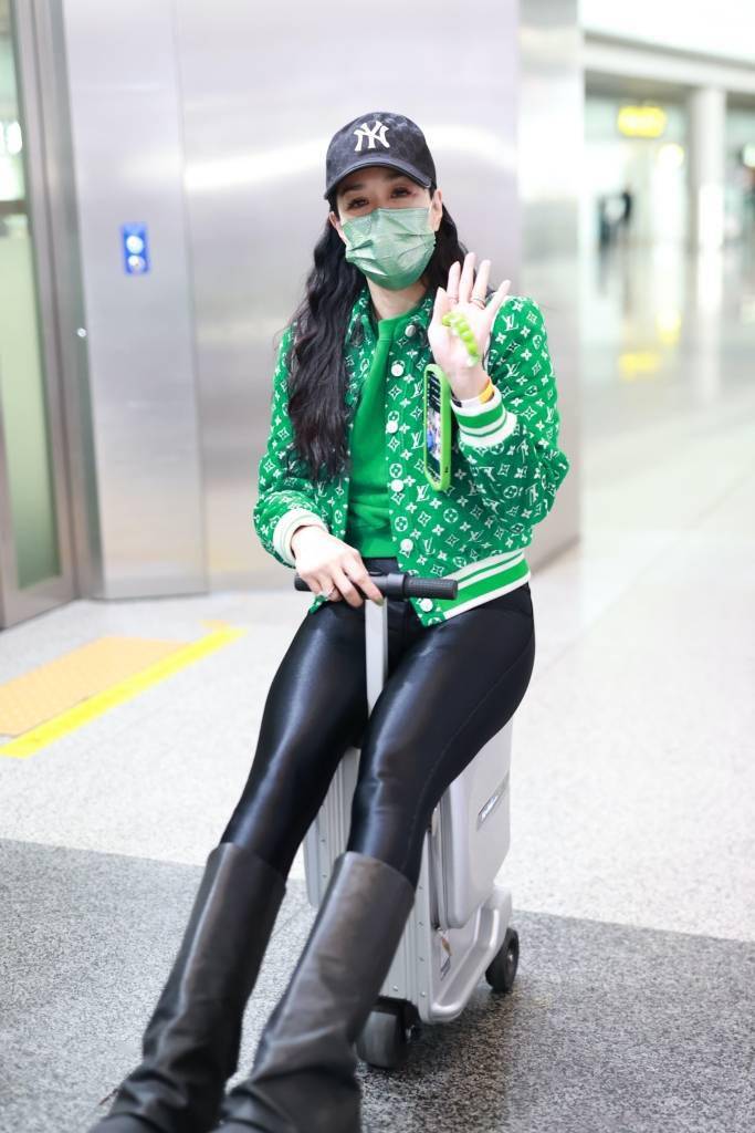 北京,钟丽缇现身首都机场,她身穿绿色提花棒球衫搭配黑色紧身裤和高筒