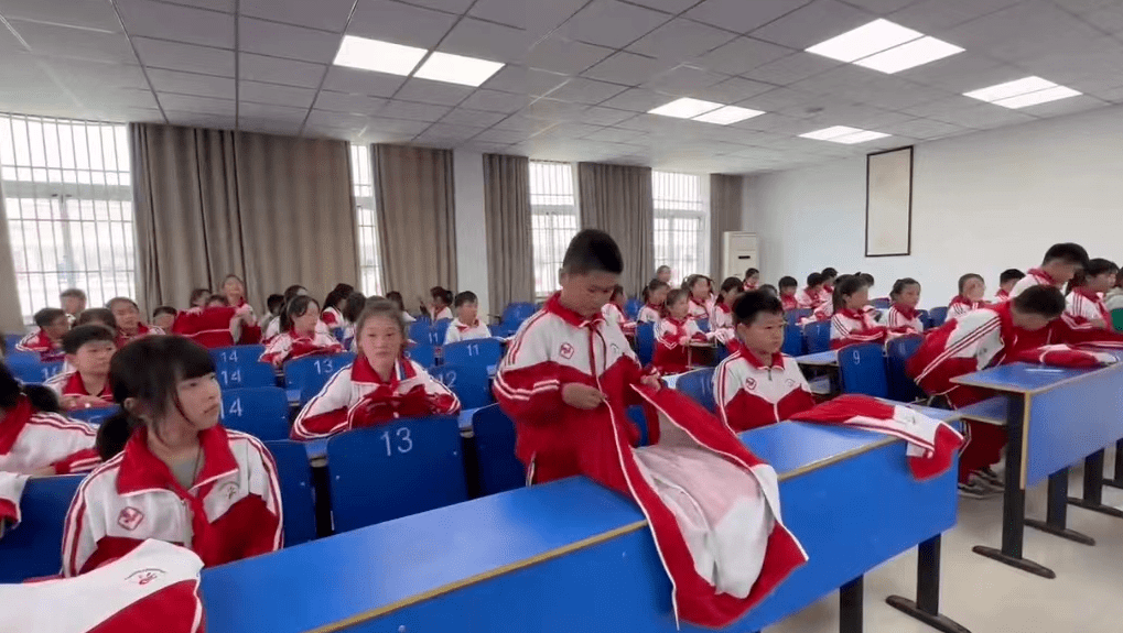 班主任利用班会指导学生在教室用校服做叠衣服练习,熟练掌握叠衣服方