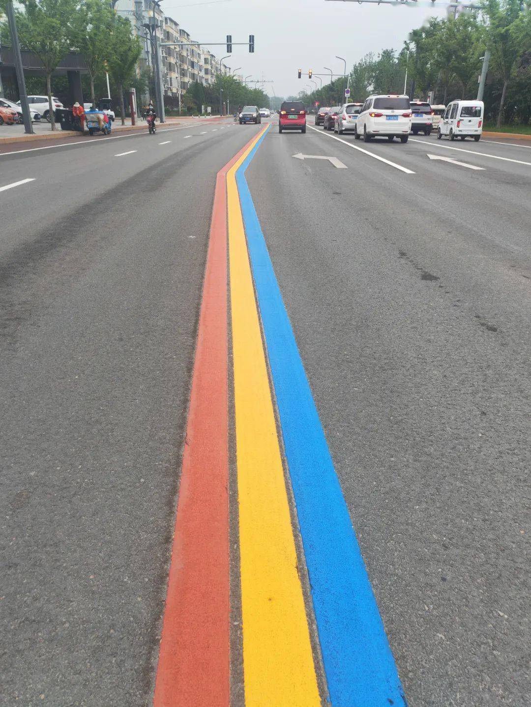 宽阔平整的马路通向远方,五彩斑斓的彩虹标线宛如大地的彩绸舞动城区