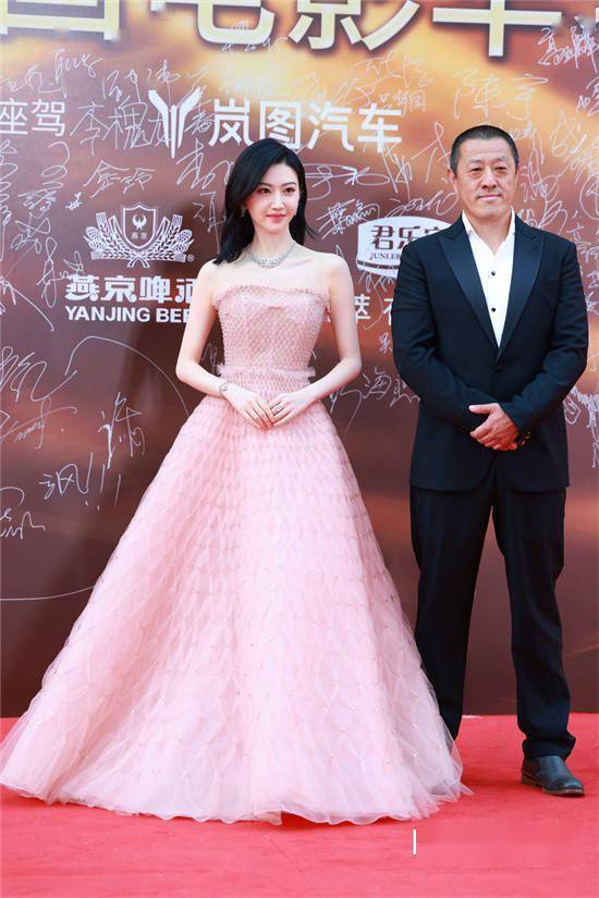 佟丽娅现身红毯现场,她身穿一件吊带白色纱裙,镂空钩花设计别出心裁