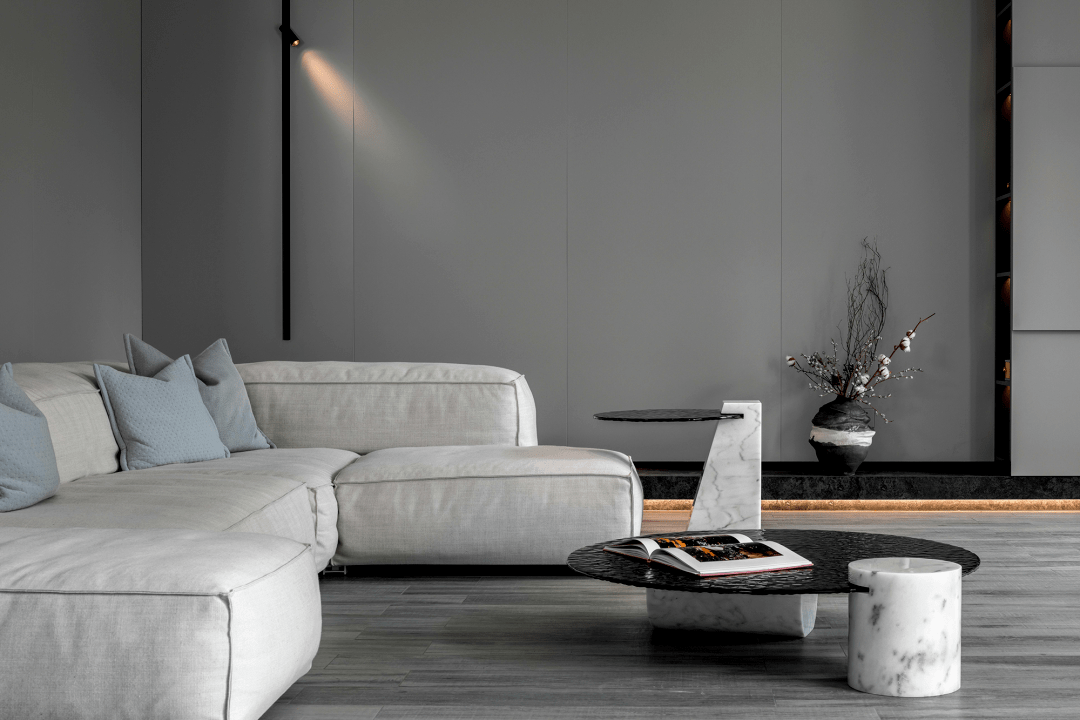灰色的墙板,家具,配饰都在浅色系中选用哑光面料,搭配温暖的木色地板