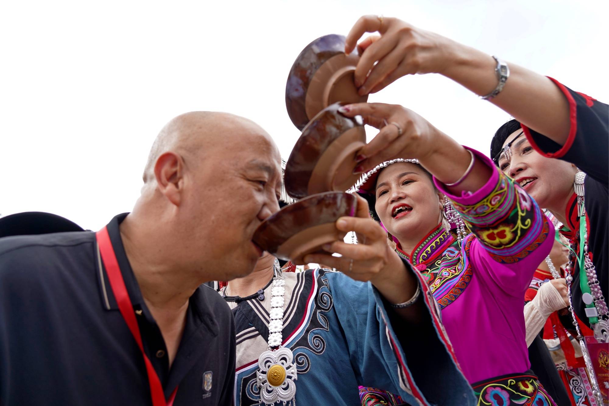 彝族女同胞分两排站在迎宾门前,唱着欢快的彝家敬酒歌,向宾客敬拦门酒