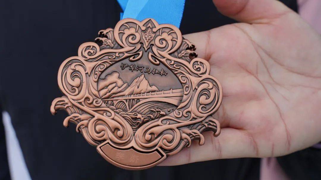 2023伊犁河马拉松的奖牌设计独具匠心,整体以"如意"爱心形状和羊角纹