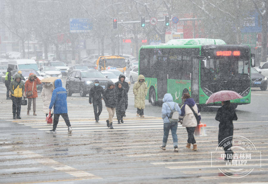 自由大路与人民大街交会处,在雨夹雪天气中出行的市民在雨夹雪天气中