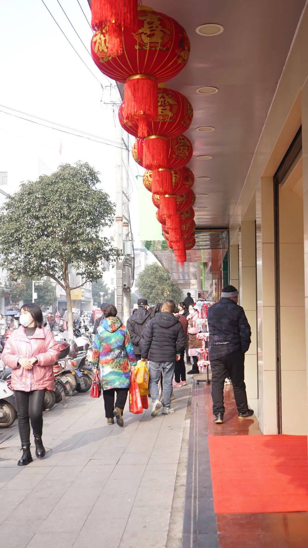 的热气腾腾热闹的景象摩肩接踵的人潮涌动在红安民主街,沃尔玛商圈